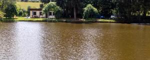 a large body of water with a house in the background at Bungalow charmant à Rochechouart avec vue sur lac in Rochechouart