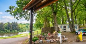 a house with a car parked in front of a lake at Bungalow charmant à Rochechouart avec vue sur lac in Rochechouart +9 photos