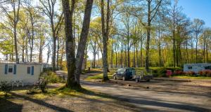 a truck parked next to a trailer and a campsite at Bungalow charmant à Rochechouart avec vue sur lac in Rochechouart