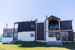 a house with a black and white facade at 33D Kabeljauws Beach in Jeffreys Bay