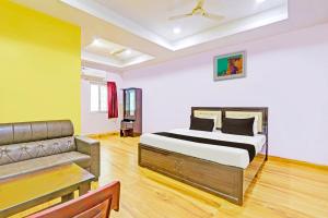 a bedroom with a bed and a couch at Hotel O Nandhi Inn in Vemalwāda
