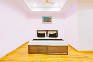 a bedroom with a bed in a white room at Hotel O Nandhi Inn in Vemalwāda