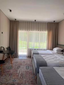 a hotel room with four beds and a table and a window at Алаша in Qotanqaraghay