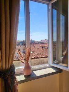 a window with a vase on a window sill with a view at Hotel Lux in Alessandria