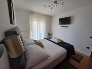 a bedroom with a large bed with a tv on the wall at Residence Gordana 2 in Selce