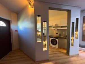 a room with a hallway with a kitchen and a door at ADAM Apartments Krāslava in Krāslava