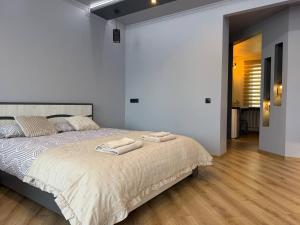 a bedroom with a bed with two towels on it at ADAM Apartments Krāslava in Krāslava