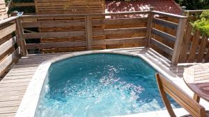 a plunge pool on a deck with a wooden fence at Maison confortable Le Moule Jacuzzi in Le Moule