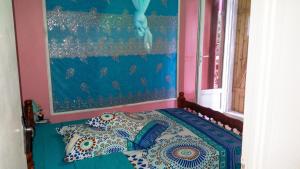 a bedroom with a bed with a painting on the wall at Maison confortable Le Moule Jacuzzi in Le Moule