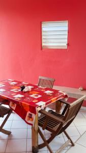 a cat laying on a table in a room with a red wall at Maison confortable Le Moule Jacuzzi in Le Moule +4 photos