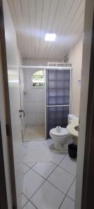 a bathroom with a toilet and a sink at Pousada Morada do Tombo in Guarujá