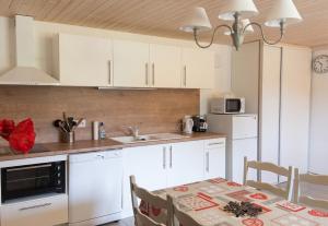 a kitchen with white cabinets and a table with chairs at Appartement confortable à Cornimont 30 m² vue montagne in Cornimont