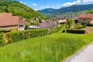 a green yard with houses and mountains in the background at Appartement confortable à Cornimont 30 m² vue montagne in Cornimont +5 photos