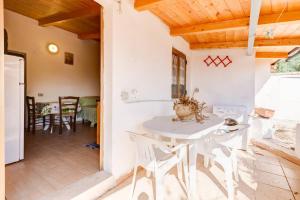 a kitchen and dining room with a white table and chairs at Charming apartment in Pisciotta, 37 m² with terrace in Pisciotta