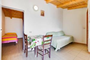 a room with a table and a bed and a table and chairs at Charming apartment in Pisciotta, 37 m² with terrace in Pisciotta
