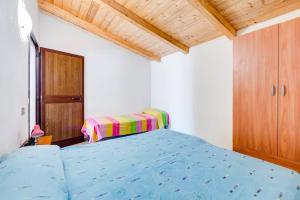 a bedroom with a blue bed and a wooden cabinet at Charming apartment in Pisciotta, 37 m² with terrace in Pisciotta +3 photos