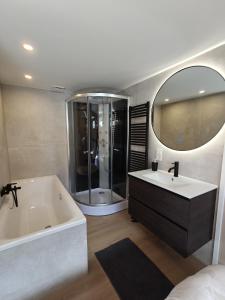 a bathroom with a tub and a sink and a mirror at Luxe 6 persoons bungalow met 3 slaapkamers 2 badkamers en ensuite ligbad in Sint Maartensvlotbrug +21 photos