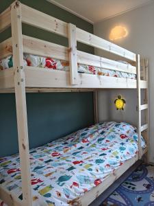a bedroom with a bunk bed with a wooden bunk bedoublethritisthritisthritisthritis at Luxe 6 persoons bungalow met 3 slaapkamers 2 badkamers en ensuite ligbad in Sint Maartensvlotbrug