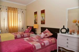 a bedroom with two beds and a dresser at Comfortable apartment with lake view in Vila Real - 75m² in Vila Real de Santo António