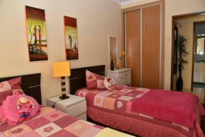 a bedroom with two beds and a lamp at Comfortable apartment with lake view in Vila Real - 75m² in Vila Real de Santo António