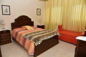 a bedroom with a large bed and a red couch at Comfortable apartment with lake view in Vila Real - 75m² in Vila Real de Santo António +16 photos