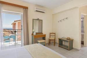 a bedroom with a bed and a view of the ocean at Porto Skala Village Hotel in Skala