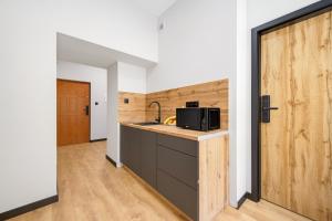 a kitchen with a microwave on a counter next to a door at Centrum Grand Apartments in Rybnik