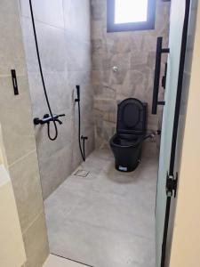 a bathroom with a black toilet in a stall at شاليهات ترف in Abha