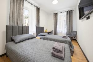 a bedroom with two beds and a window at Centrum Grand Apartments in Rybnik