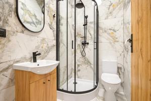 a bathroom with a shower and a toilet and a sink at Centrum Grand Apartments in Rybnik