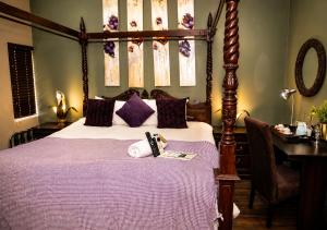 a bedroom with a bed with purple sheets and a desk at Moonriver Guesthouse in Upington +50 photos