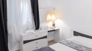 a bedroom with a bed and a dresser with a lamp at Villa enchanteresse à Saint-Benoît avec piscine privée in Saint-Benoît