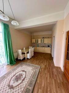 ein Wohnzimmer mit einem Tisch und einer Küche in der Unterkunft fourth line in Riga