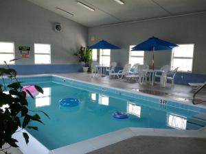 una gran piscina con sillas y sombrillas en Brook Pointe Inn, en Syracuse