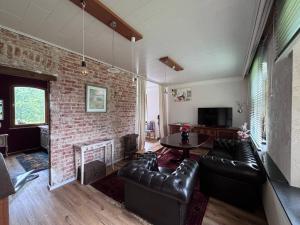 a living room with leather furniture and a brick wall at Tischlerei in Barum