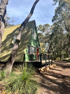 a green house sitting in the middle of a forest at Hakea at Porongurup Chalets in Porongurup