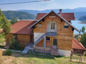 a log house with a staircase in front of it at Vila Arena in Mandići
