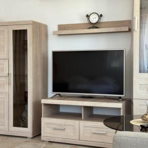 a living room with a television on a wooden entertainment center at Villa Guci in Ulcinj