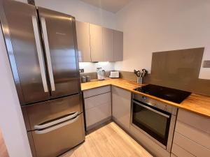 a kitchen with a stainless steel refrigerator and wooden counters at Central City stays in Exeter