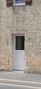 a white door in a stone building with a window at La maisonnette in Coulombs