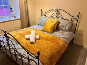 a bed with two towels and pillows on it at Central City stays in Exeter