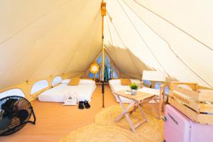 a tent with a bed and a table in it at Kampaoh Playa Troenzo in Celorio +26 photos