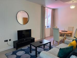 a living room with a couch and a table and a mirror at Central City stays in Exeter