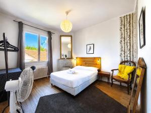 a bedroom with a bed and a large window at " Le Grand Biarritz " Jardin - Parking - WIFI in Toulouse