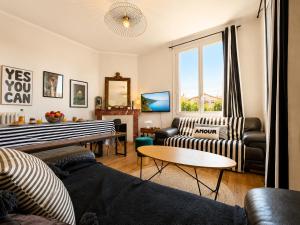 a living room with two couches and a table at " Le Grand Biarritz " Jardin - Parking - WIFI in Toulouse