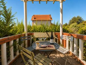 a table and chairs on a balcony with a bottle of wine at " Le Grand Biarritz " Jardin - Parking - WIFI in Toulouse