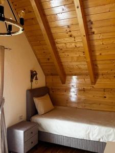 a bed in a room with a wooden ceiling at Hanovi Apartments in Borje