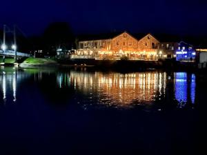 a building with lights on the water at night at Central City stays in Exeter