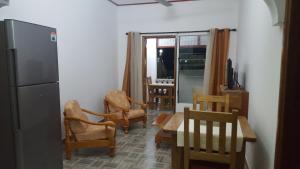 a kitchen with chairs and a table and a refrigerator at Comfortable apartment in Baie Sainte Anne 56 m² with sea view in Baie Sainte Anne