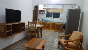 a living room with a tv and a table and chairs at Comfortable apartment in Baie Sainte Anne 56 m² with sea view in Baie Sainte Anne